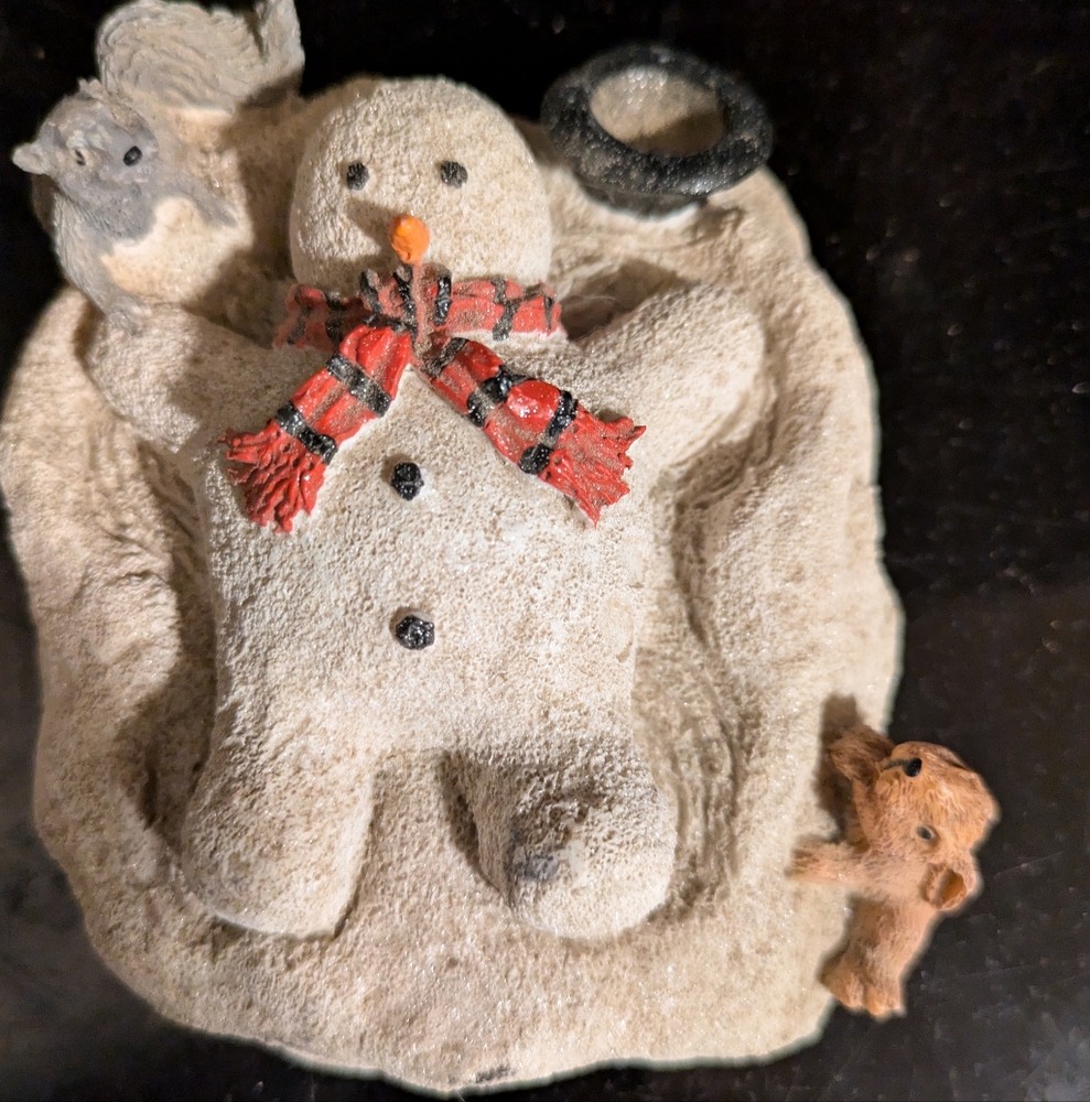 Winter figurine. Snowman making snow angel.